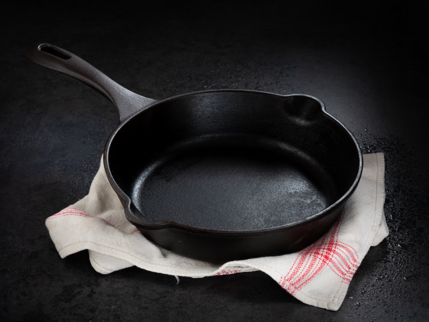 Empty cast iron pan on kitchen cloth