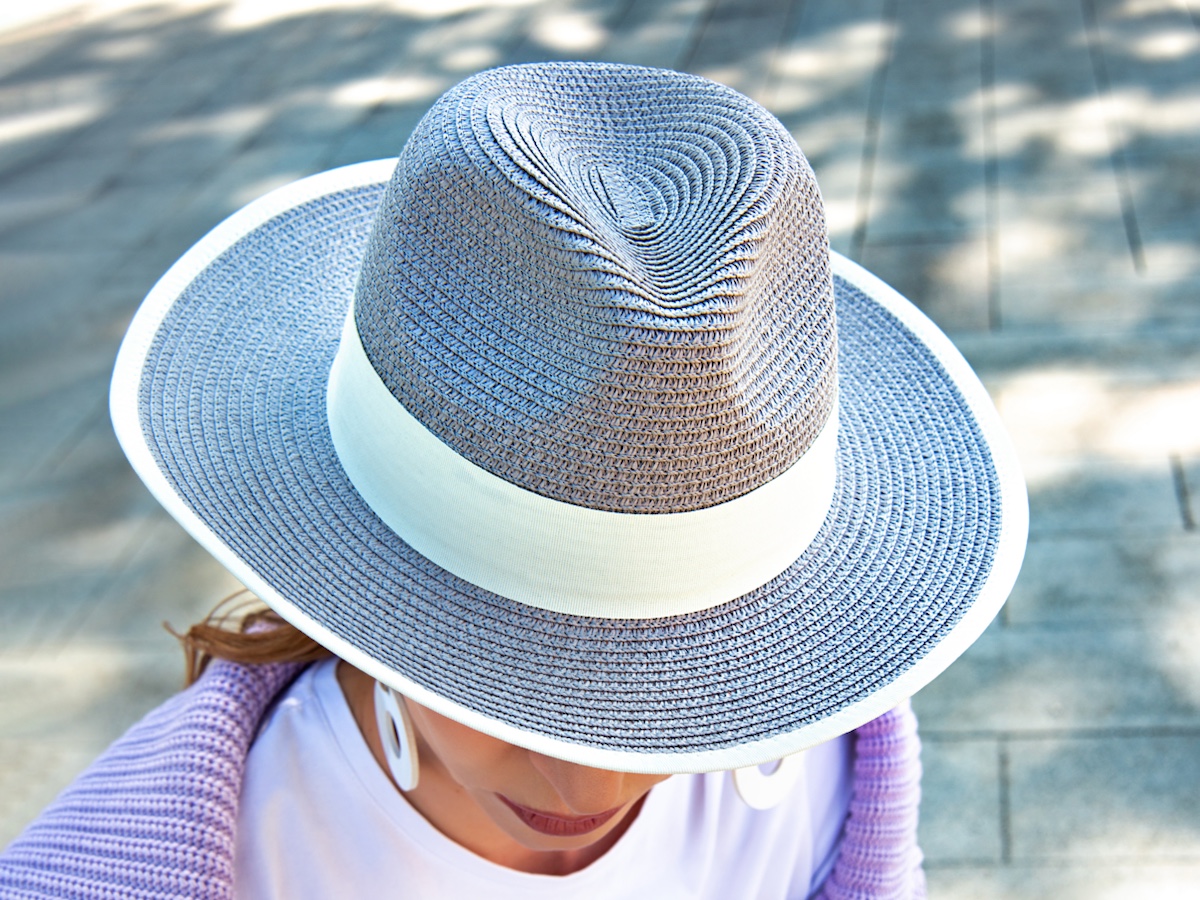 Gray wicker hat with wide brim. Summer hat with wide brim and white stripe.