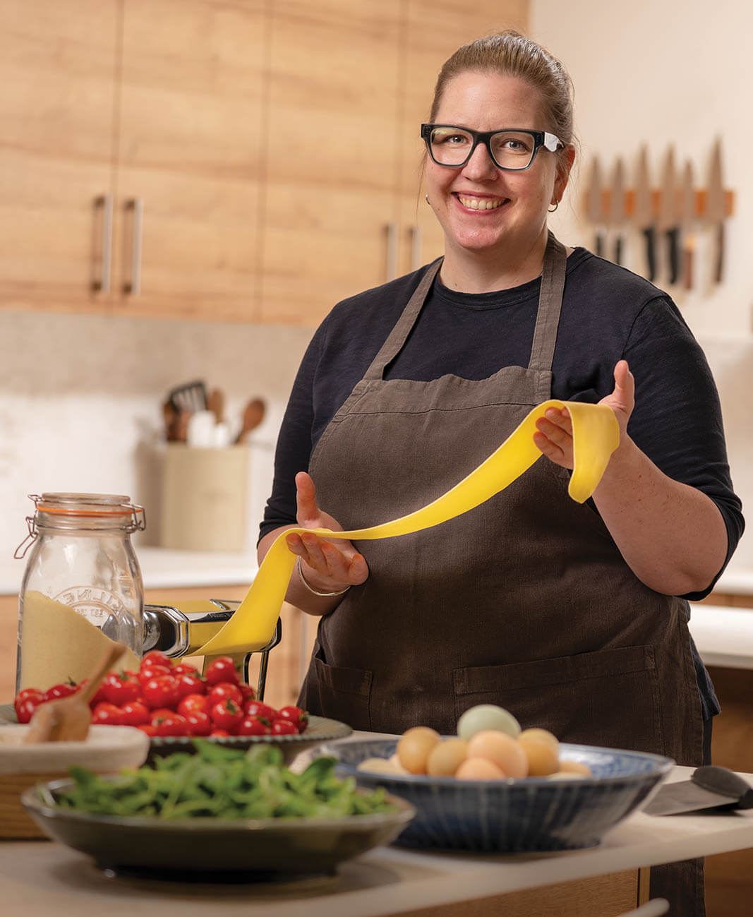 AwnKitchen_KaelinWhittaker_StandingInKitchen_RollingPasta