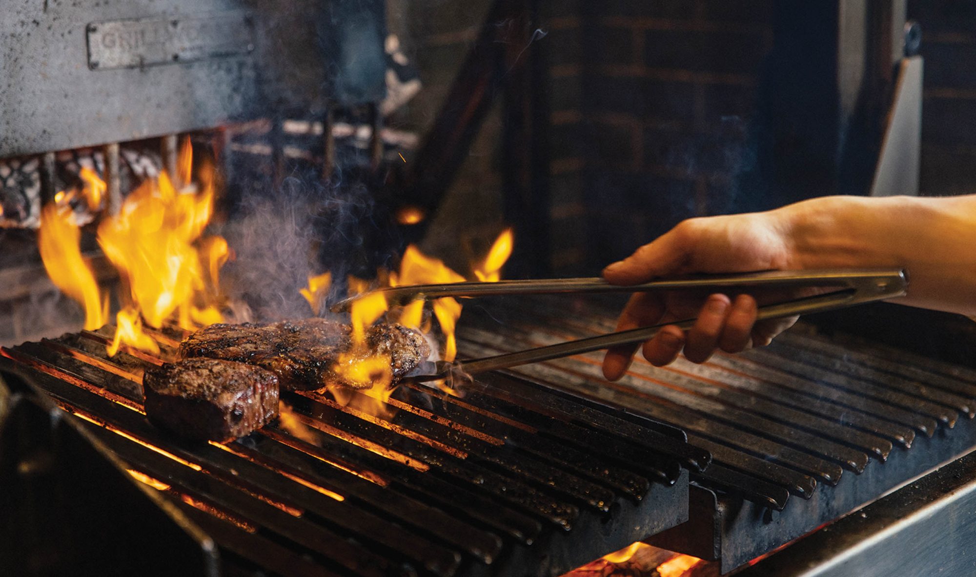 Barbacoa_TurningSteakOnGrill