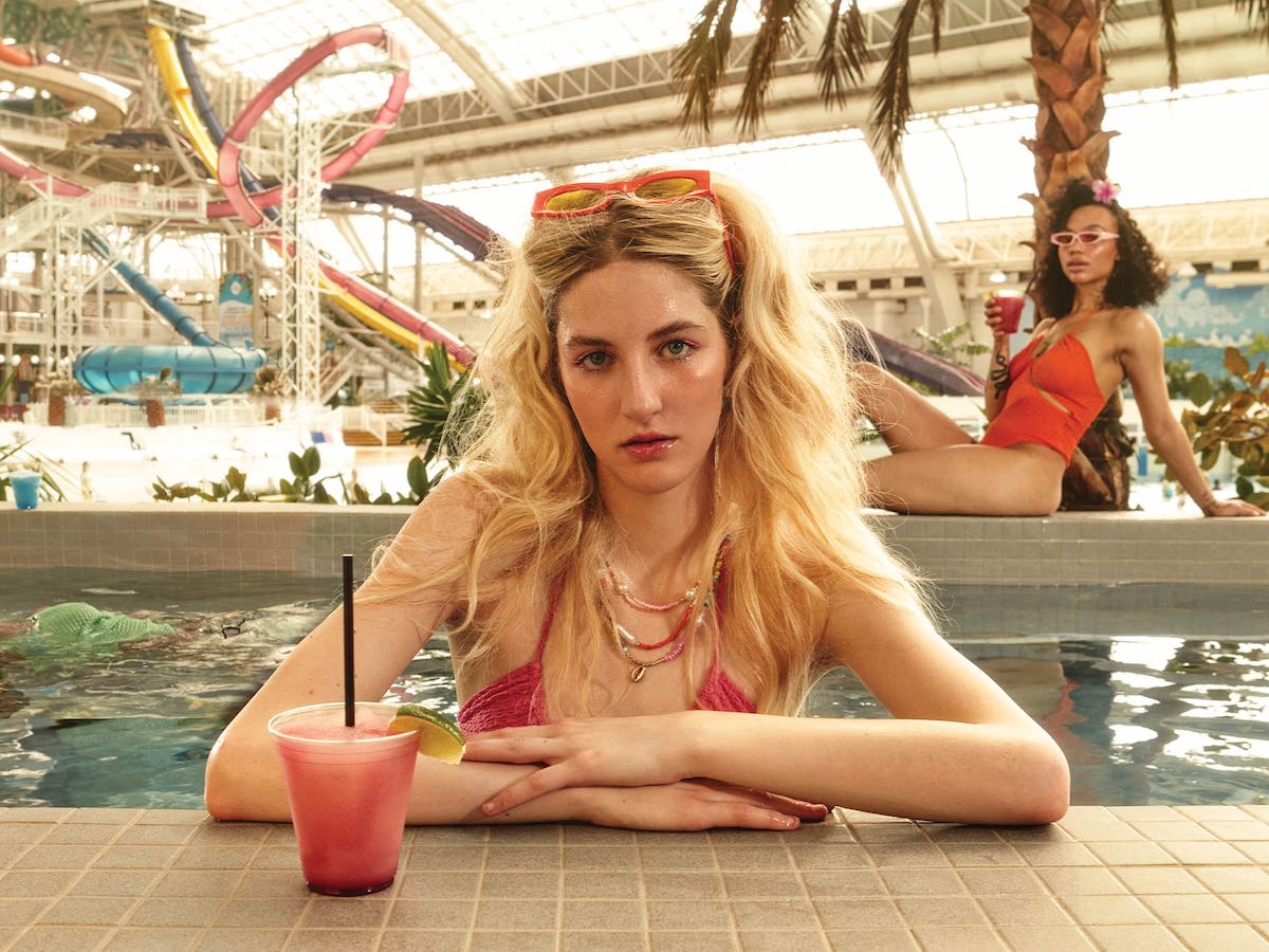 BlondeFemale_ElbowsOnHottubEdge_ModelRecliningAgainstTreeInBack