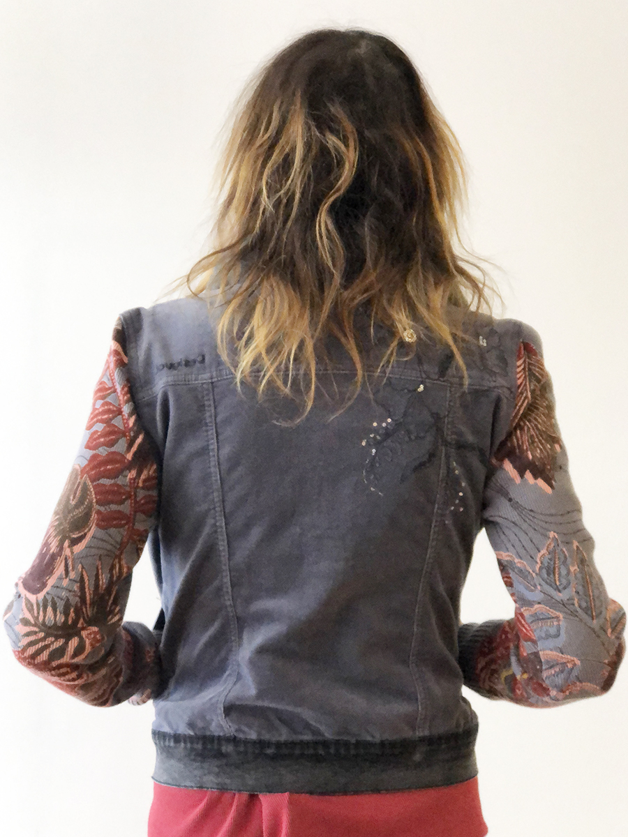 The denim jacket has sleeves decorated with red designs