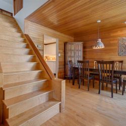 Wood stairs, wood ceiling, wood floor; slightly darker wood furniture. 