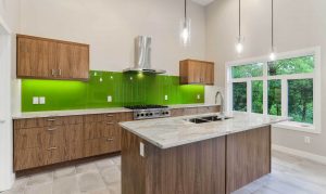 Open, kitchen with beautiful green backsplash and large windows