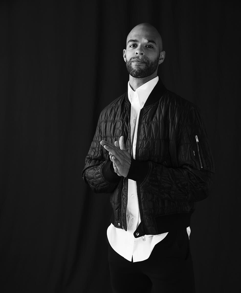 Darnel Nurse_StandingBlackQuiltedJacket_WhiteShirt Darnel Nurse_StandingBlackQuiltedJacket_WhiteShirt