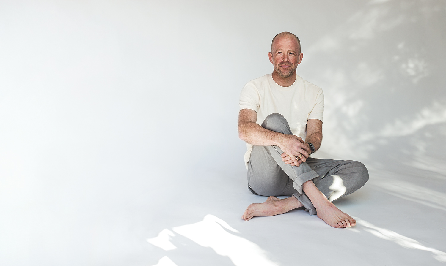 DarrenMarkland_SittingOnFloor_CrossedLegsHoldingKnee