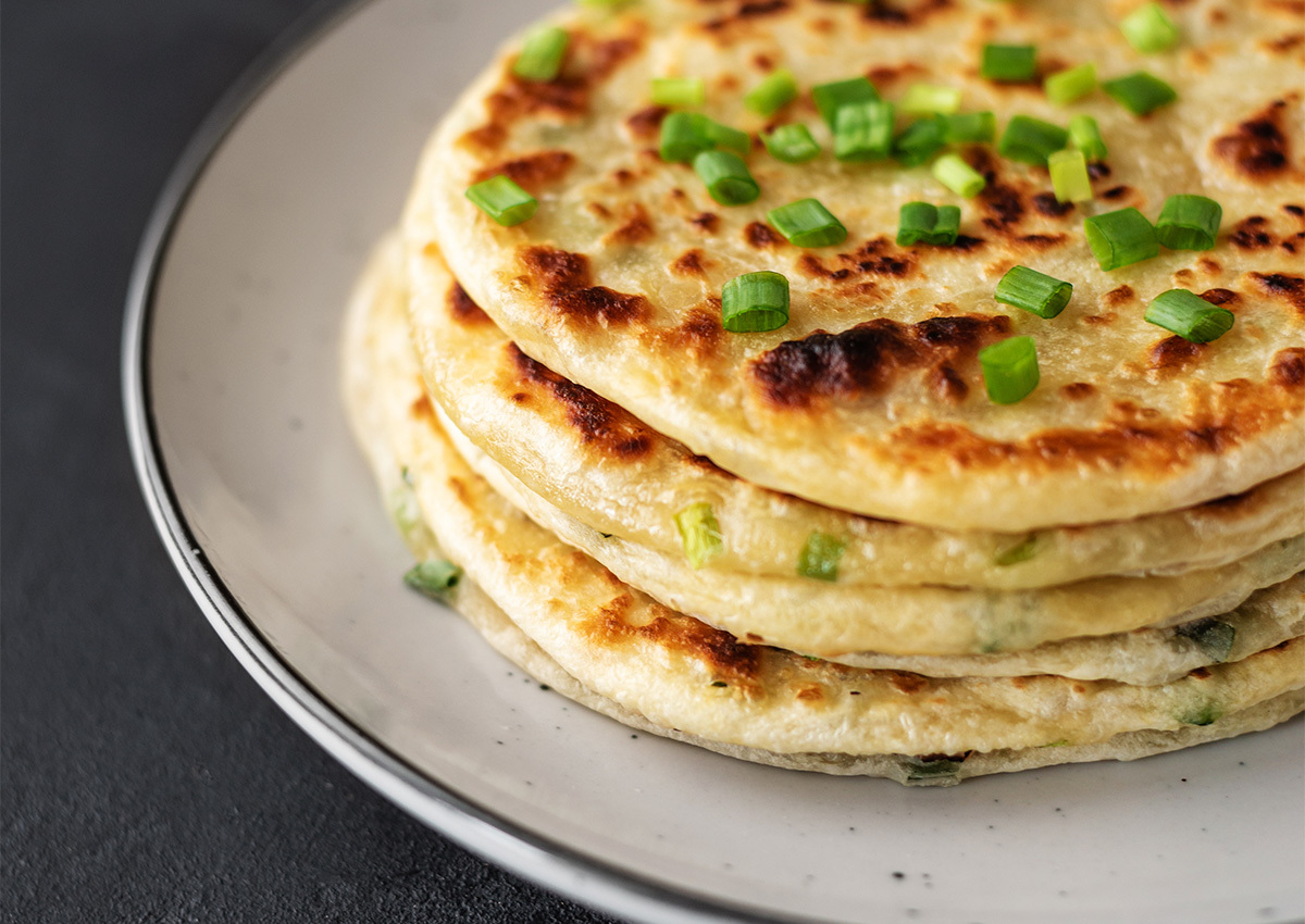 Chinese green onion pancakes on a black background.