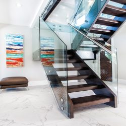 Floating staircase from Prestige Railings & Stairs Ltd.; marble tile flooring from Monarch Carpet One Floor & Home; painting by Maggie Kozina.