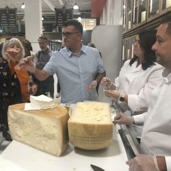 Cracking open a wheel of cheese from Parma. The store's wall of cheese can hold up to 32 large wheels.