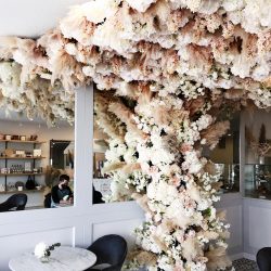 Faux flowers scaling the wall and ceiling