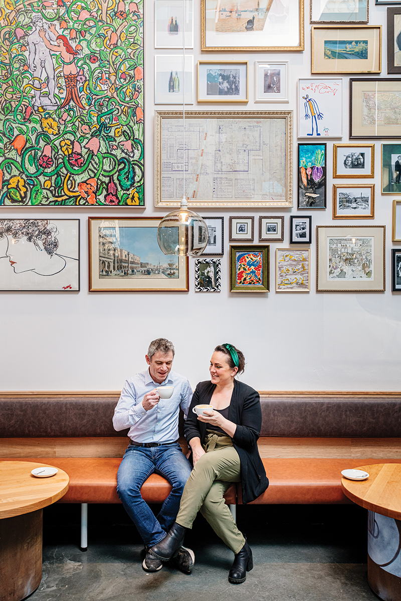 SanHuget_ElisaZenari_SittingOnOrangeBenchSeatInRestaurant