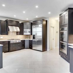 Kitchen with white ceiling and tile floor; dark brown cupboards and cabinets