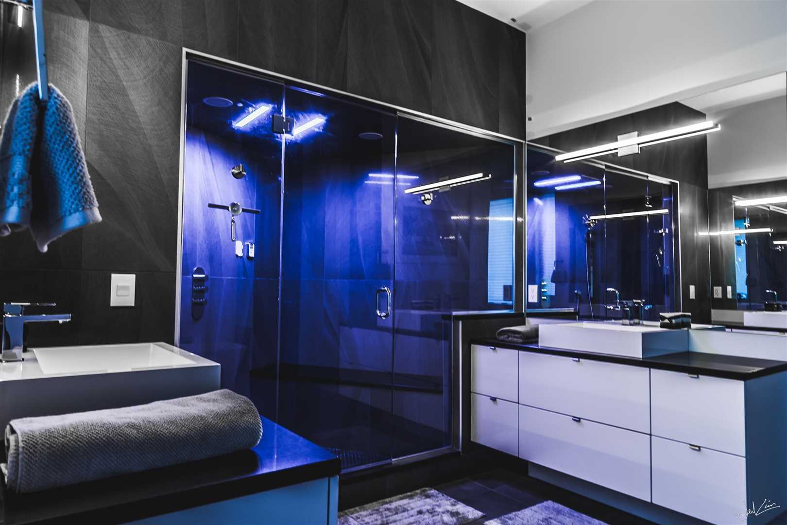 Black and white bathroom with shower that lights up blue