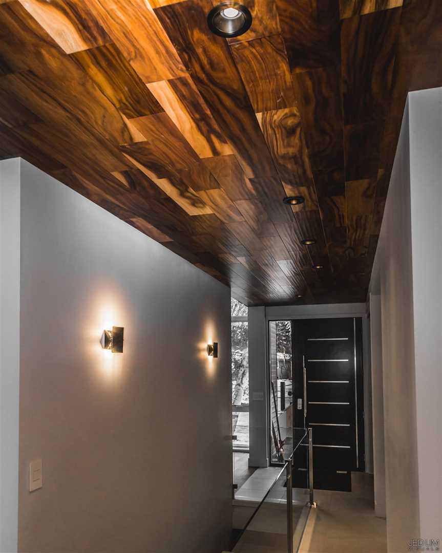 Front entrance hallway with white walls and a freakin' hardwood ceiling leading to black door