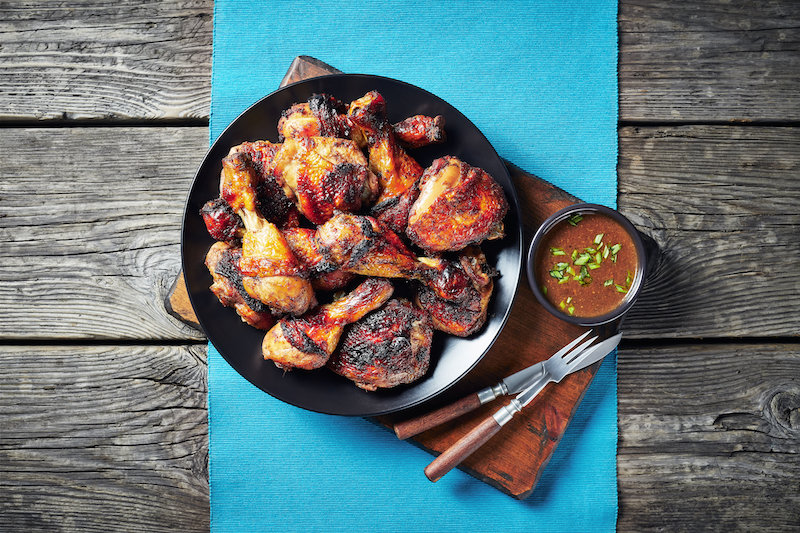 Jerk,Chicken,On,A,Black,Plate,On,A,Table,Mat