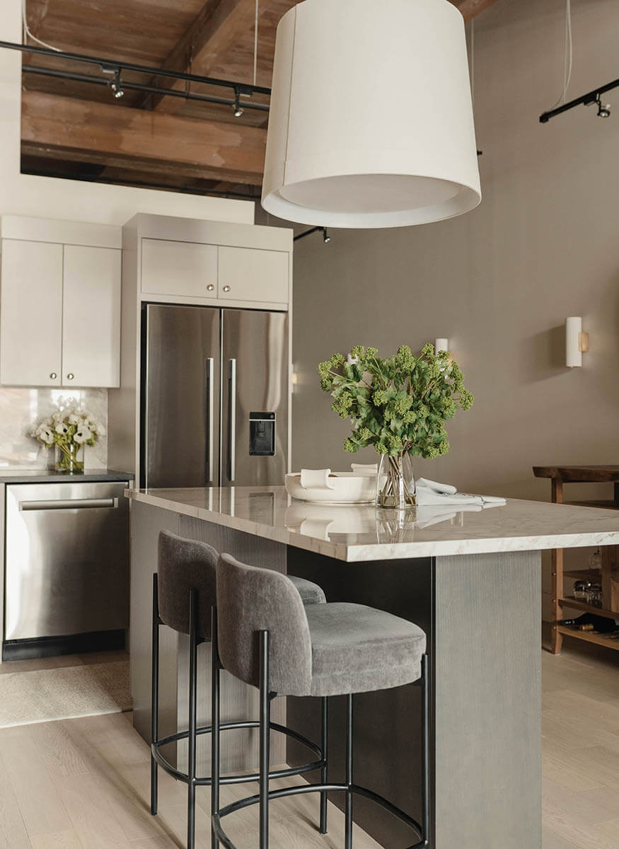 house 5 - KitchenIsland_White_LargeWhiteLampShadeOver_BrownWoodCeiling_StainlessFridge